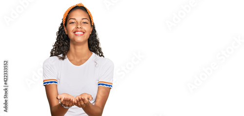 Young african american girl wearing casual clothes smiling with hands palms together receiving or giving gesture. hold and protection