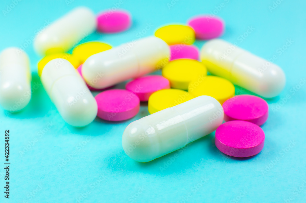 Colored pills and tablets on green background. Close up. Medical treatment concept. Colored pills and tablets on green background. Close up. Medical treatment concept.