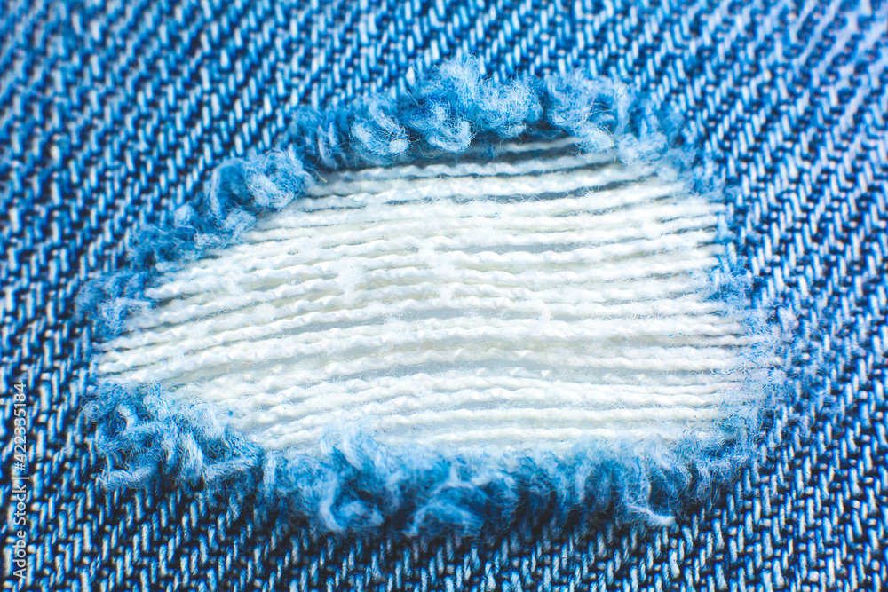 Ripped blue hipster jeans material. Destroyed denim Cloth texture. Close  up. Stock Photo | Adobe Stock