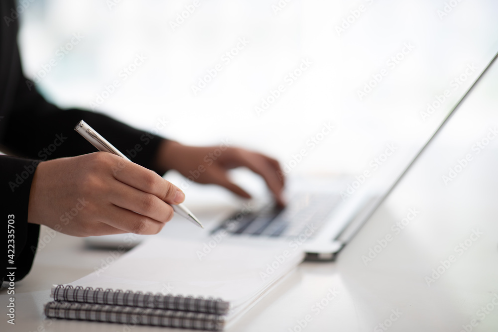 Close up of Accounting businesswoman working on note laptop computer and analyzing real estate investment data, Financial and tax systems concept.