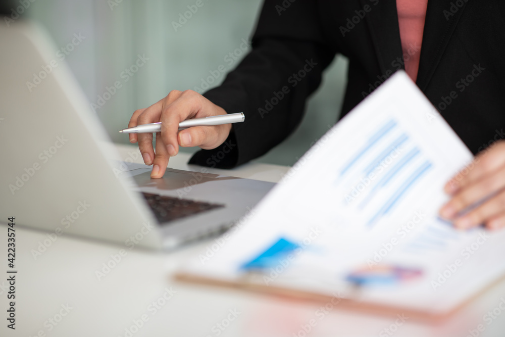 Close up of Accounting businesswoman working on note laptop computer and analyzing real estate investment data, Financial and tax systems concept. Close up of Accounting businesswoman working on note laptop computer and analyzing real estate investment data, Financial and tax systems concept.