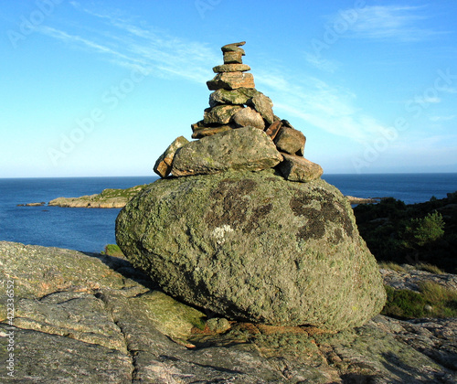 Stone cairn in Scandinavia, navigation mark on the shore of a Nordic fjord.