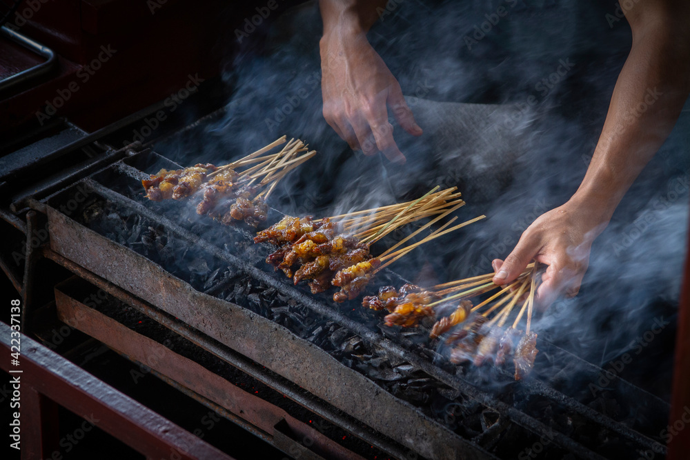 Chicken satay grill at a busy street food market Chicken satay grill at a busy street food market