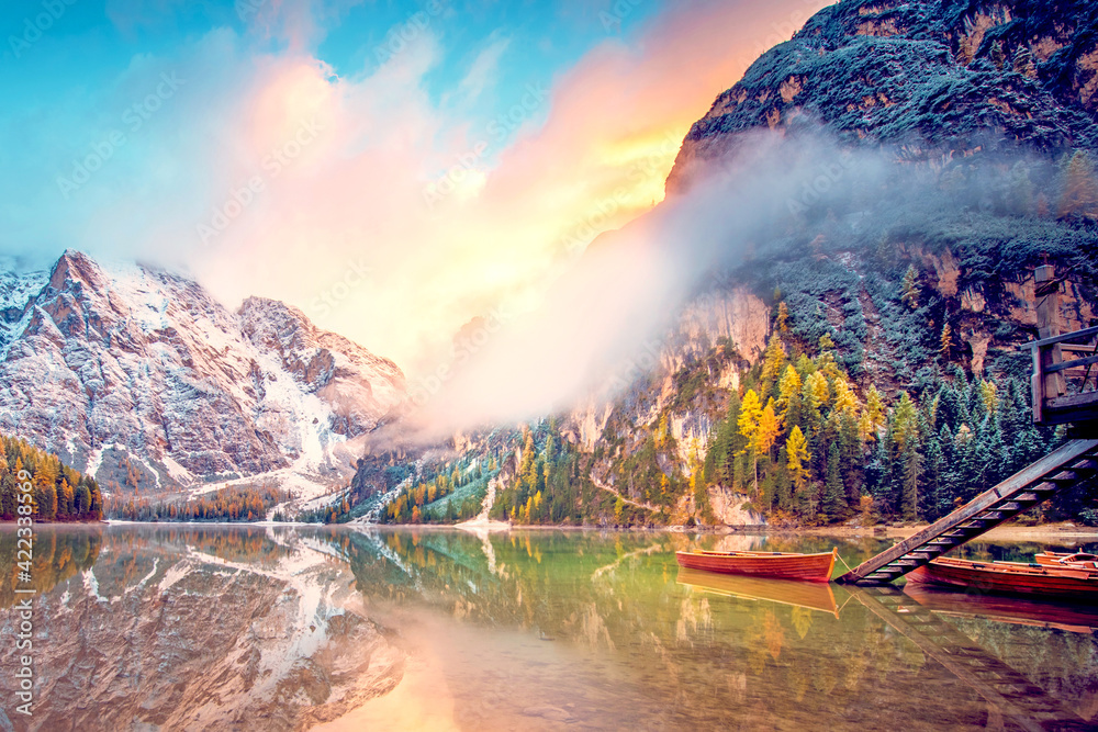 Unmatched autumn landscape with boats on the lake with sunrise on Fanes-Sennes-Braies natural park in the Dolomites in Alps, Italy, Europe. (