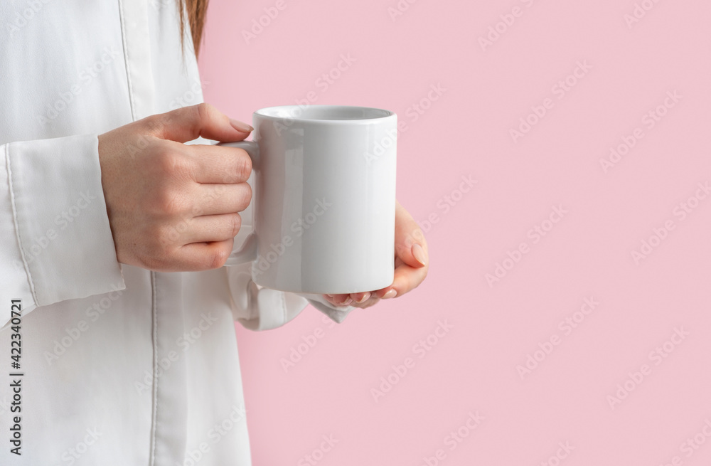 mockup white coffe cup or mug in female hands on pink background with copy space. Blank template for your design, branding, business. Real photo. Woman in shirt casual style mockup white coffe cup or mug in female hands on pink background with copy space. Blank template for your design, branding, business. Real photo. Woman in shirt casual style
