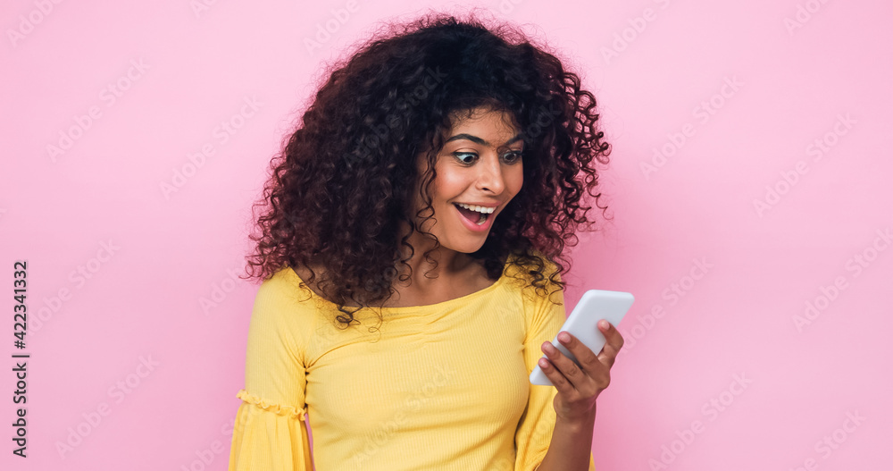 positive young woman holding mobile phone isolated on pink positive young woman holding mobile phone isolated on pink