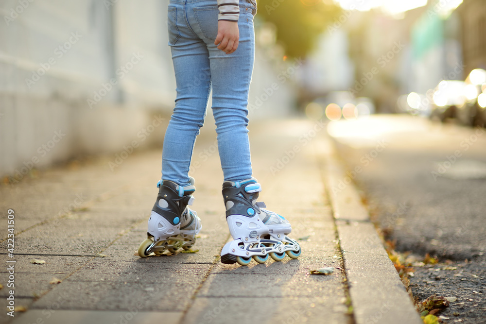 Young girl learning to roller skate on beautiful summer day on a street. Young girl learning to roller skate on beautiful summer day on a street.
