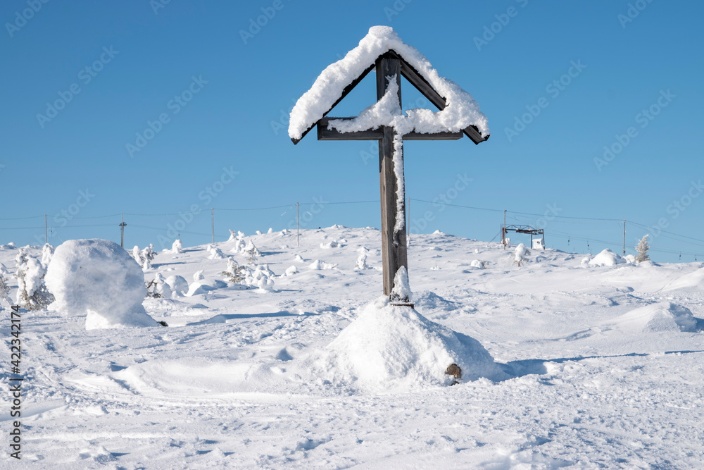Fototapeta premium Snowy cross on top of mountain in Lapland Finland