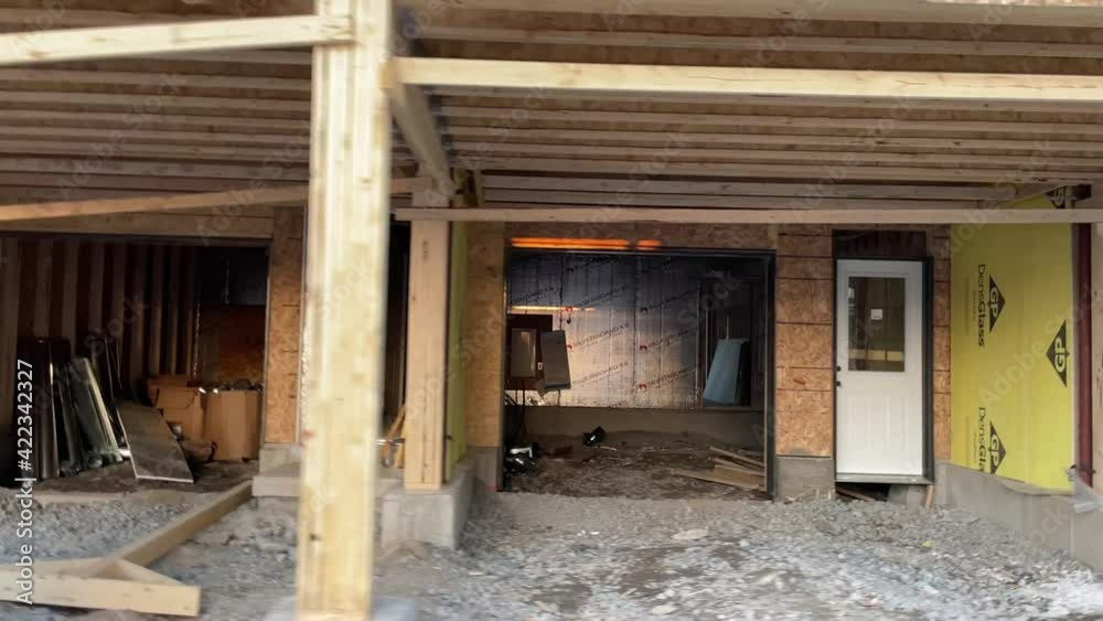 Close-up of Garage and Entrance construction of new development neighborhood town home community in Canada with wooden foundation, frame, isolation, and being complete by residential builders in city Close-up of Garage and Entrance construction of new development neighborhood town home community in Canada with wooden foundation, frame, isolation, and being complete by residential builders in city