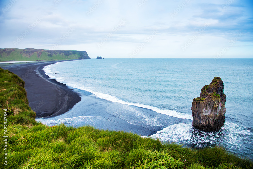 Magical amazing dramatic scenic landscape with big alone stone in the middle of the ocean nearby Reynisdrangar Sea Cliffs, near cape Dyrholaey and Vik, Iceland. Exotic countries. Amazing places.