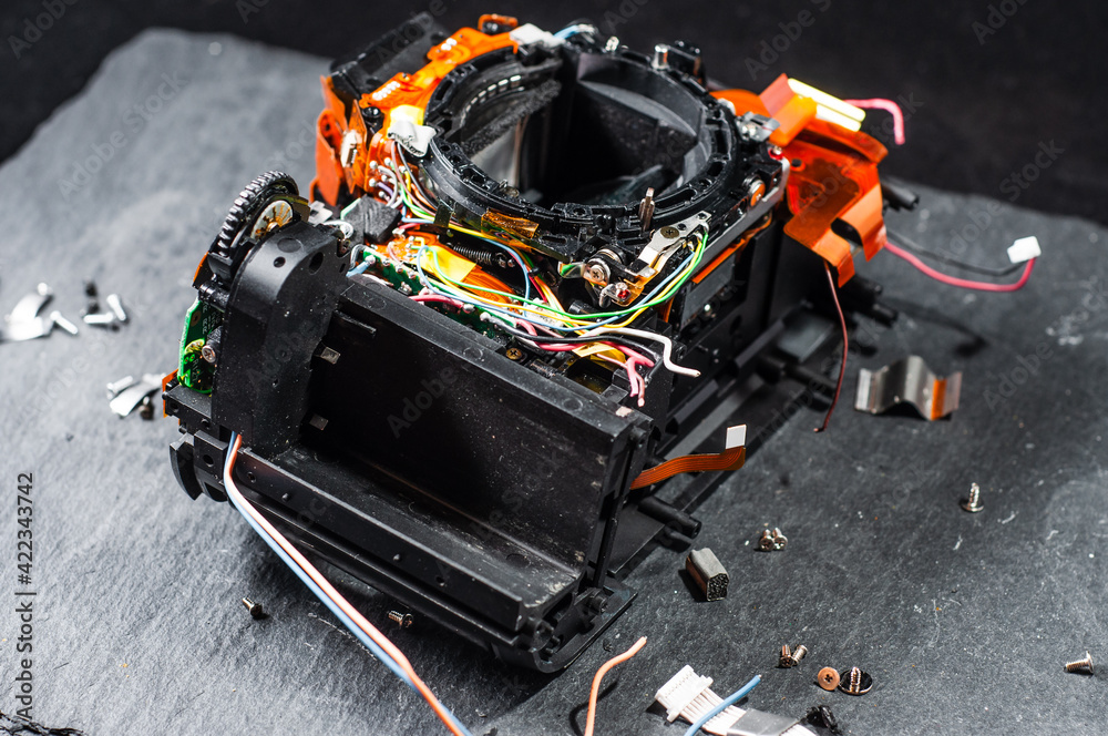 The disassembled camera lies on the subject table in the repair service