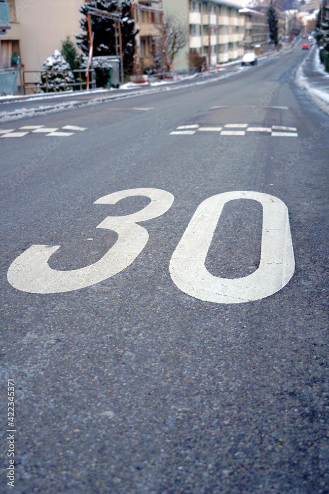 Obraz premium Speed limit marking of 30 km per hour zone as a form of speed management in residential areas in some jurisdictions in Europa. Maximum speed limits in these zones are 30 km per hour.