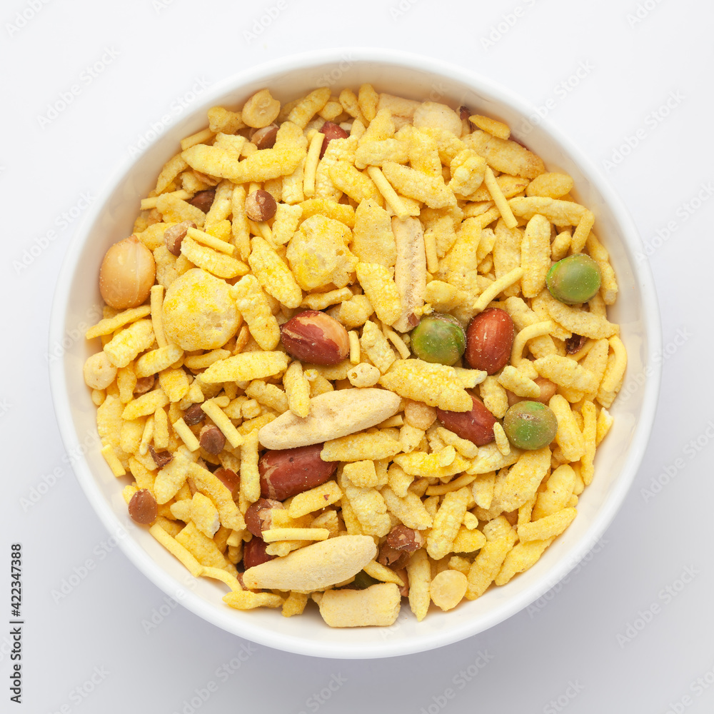 Delicious Khatta Meetha in a white Ceramic bowl, made with peanuts, sugar, raisins, and besan sev. Pile of Indian spicy snacks (Namkeen), Top view Delicious Khatta Meetha in a white Ceramic bowl, made with peanuts, sugar, raisins, and besan sev. Pile of Indian spicy snacks (Namkeen), Top view