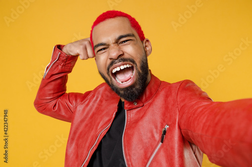 фотографія Close up young african smiling man with funky trendy pink hairdo in red leather