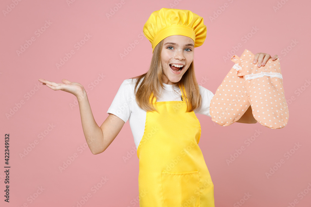 Teen confused girl chef cook confectioner baker housewife in yellow apron white t-shirt toque cap kitchen mitten potholder spread hand gesture isolated on pink background studio portrait Food concept. Teen confused girl chef cook confectioner baker housewife in yellow apron white t-shirt toque cap kitchen mitten potholder spread hand gesture isolated on pink background studio portrait Food concept.