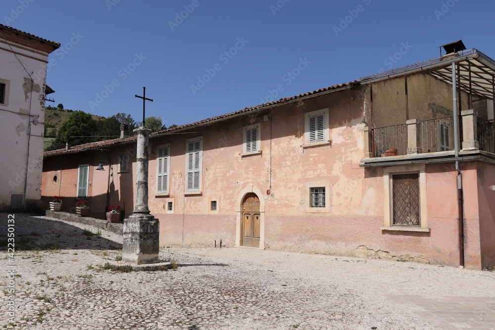 Old Pink Building with Cross on a Column in Central Italy Village