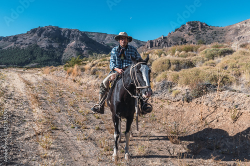  Argentine cowbow (gaucho) walks his horse past camera, in Patagonia. © SobrevolandPatagonia