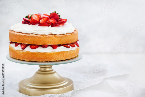 Photo Victoria`s sponge cake, delicious homemade vanilla cake decorated with whipped c