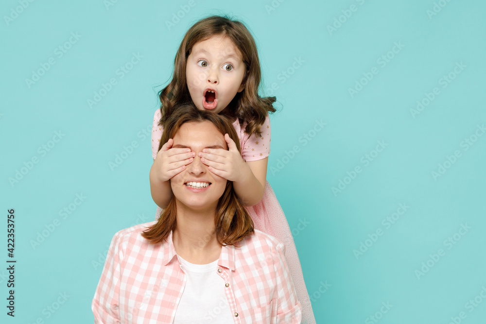 Happy woman in pink clothes have fun with child baby girl 5-6 years old Mommy little kid daughter stand behind hug kiss isolated on pastel blue azure background studio Mothers Day love family concept