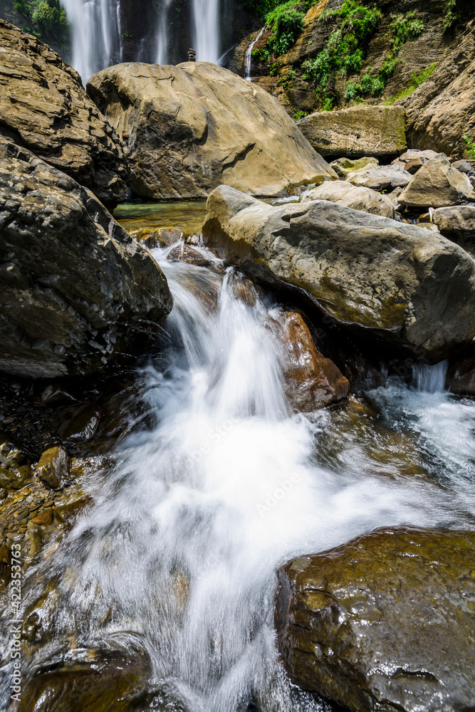 The stones under the waterfall, close-up waterfall as background.