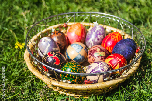 Defocus multicolored easter eggs. Decorated pysanka and krashanka. Wooden Basket With Easter Eggs In The Green Grass. Close-up. Festive. Out of focus photo