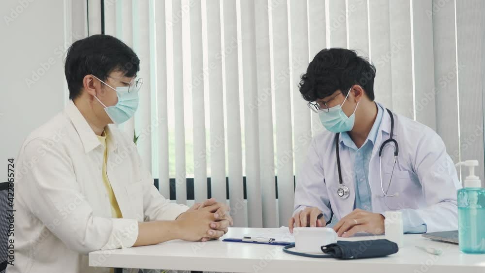 Doctors are explaining the treatment of a patient's illness while wearing a mask during the epidemic. Doctors are explaining the treatment of a patient's illness while wearing a mask during the epidemic.