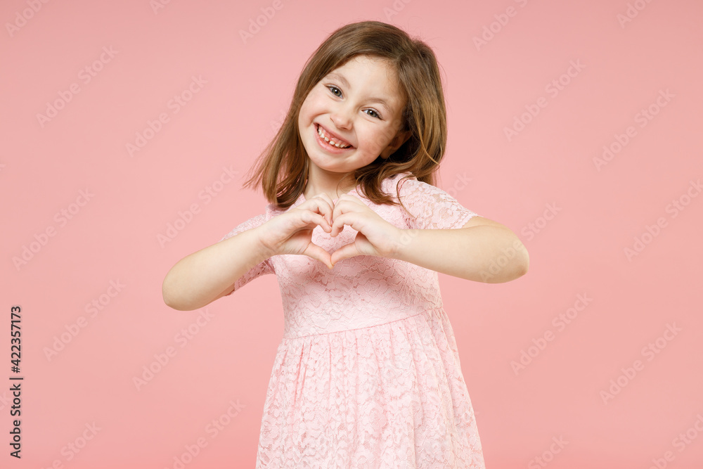 Little cute kid girl 5-6 years old wears rosy dress have fun showing shape  heart