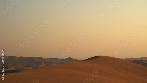Landscape of desert dunes at sunset on a windy day