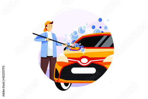Young man washing his car on the car wash self service