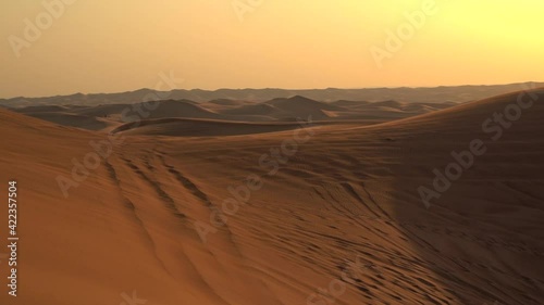 Landscape of desert dunes at sunset on a windy day