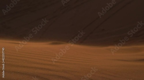 Landscape of desert dunes at sunset on a windy day