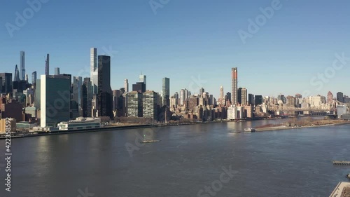Wallpaper Mural A high angle view looking north over the East River on a sunny day. The drone camera truck right and pan left from uptown to midtown Manhattan. The river is calm and empty. Torontodigital.ca