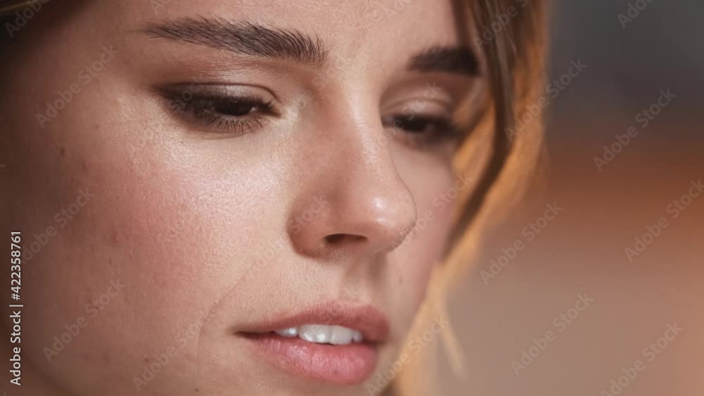 A close-up view of a serious businesswoman with wired earphones is using with her laptop while working in the office A close-up view of a serious businesswoman with wired earphones is using with her laptop while working in the office
