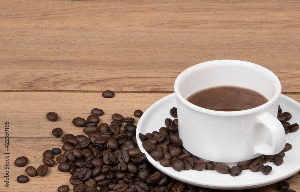 Coffee cup with coffee beans on the wooden background