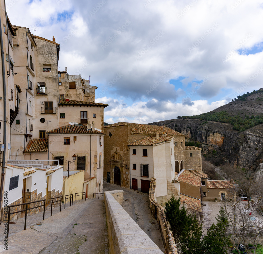 view of the old city center in Cuenca with a narrow street leading down to the Casas Colgadas or 