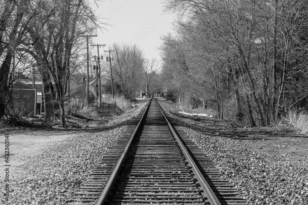 Train track disappearing into the horizon of rural America. Either a path out of town or a road to nowhere.