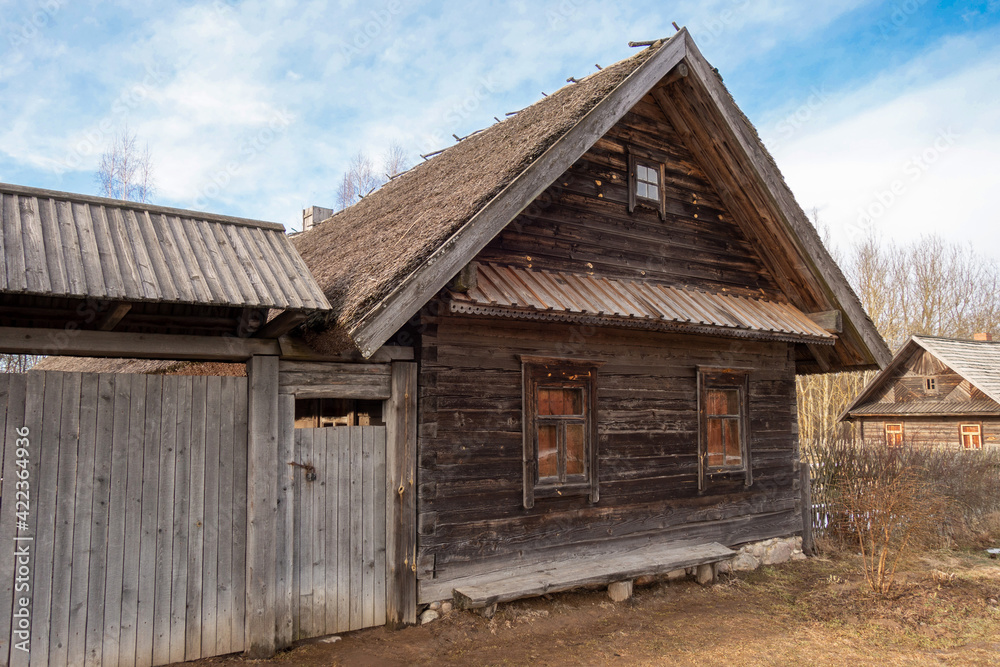 old wooden peasant hut with a bench and a gate old wooden peasant hut with a bench and a gate