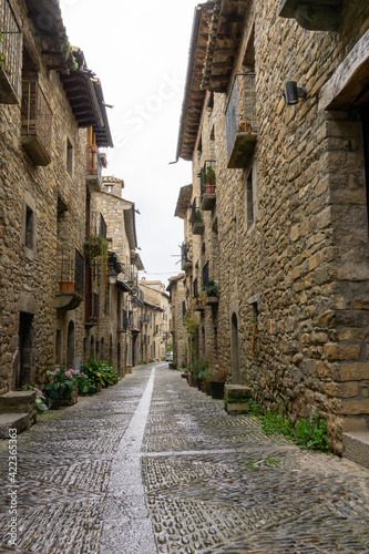 narrow cobblestone street with massive brown stone houses © makasana photo