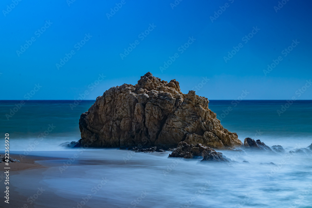 roca en medio del mar con un cielo azul