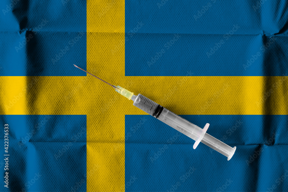 Concept of the ongoing efforts by Sweden to deliver and distribute COVID-19 Vaccine with a syringe ready to use on a Swedish flag.