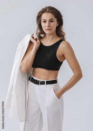 Beauty Fashion brunette model girl wearing stylish suit. Photoshoot in studio