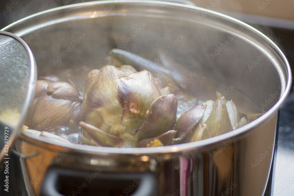 Globe Artichokes (Cynara cardunculus var. scolymus), also known by the names French artichoke and green artichoke, being cooked in a pot with boiling water and lemons Globe Artichokes (Cynara cardunculus var. scolymus), also known by the names French artichoke and green artichoke, being cooked in a pot with boiling water and lemons