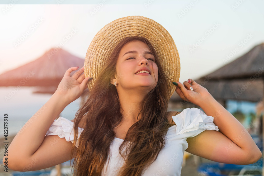 Portrait of teenage cheerful plus size teenage girl wearing hat enjoying the beach. smiling, happy, positive emotion, summer style.