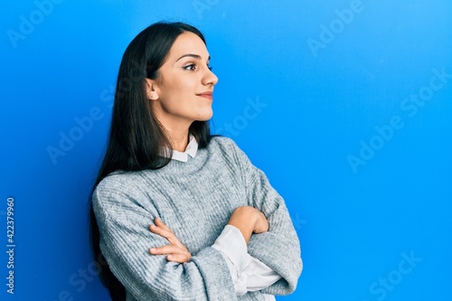 Young hispanic woman wearing casual clothes looking to the side with arms crossed convinced and confident