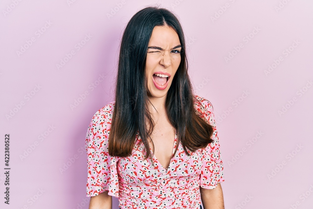 Young brunette woman wearing summer dress winking looking at the camera with sexy expression, cheerful and happy face. Young brunette woman wearing summer dress winking looking at the camera with sexy expression, cheerful and happy face.