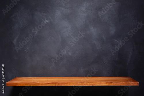 Wooden shelf and painted background texture as abstract wall surface. Book shelf at wall background
