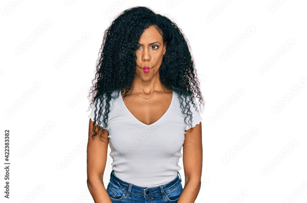 Middle age african american woman wearing casual white t shirt making fish face with lips, crazy and comical gesture. funny expression. Middle age african american woman wearing casual white t shirt making fish face with lips, crazy and comical gesture. funny expression.