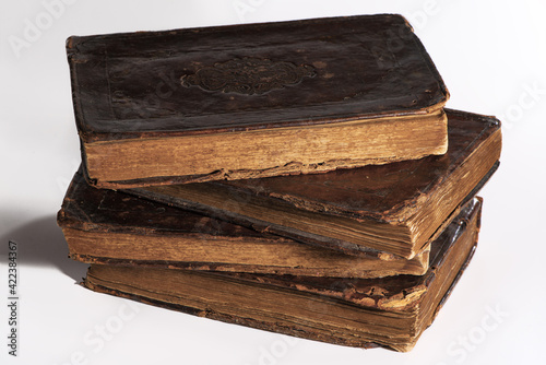 Obraz na płótnie Stack of old worn out leather-bound books isolated on white background. Closeup. w salonie