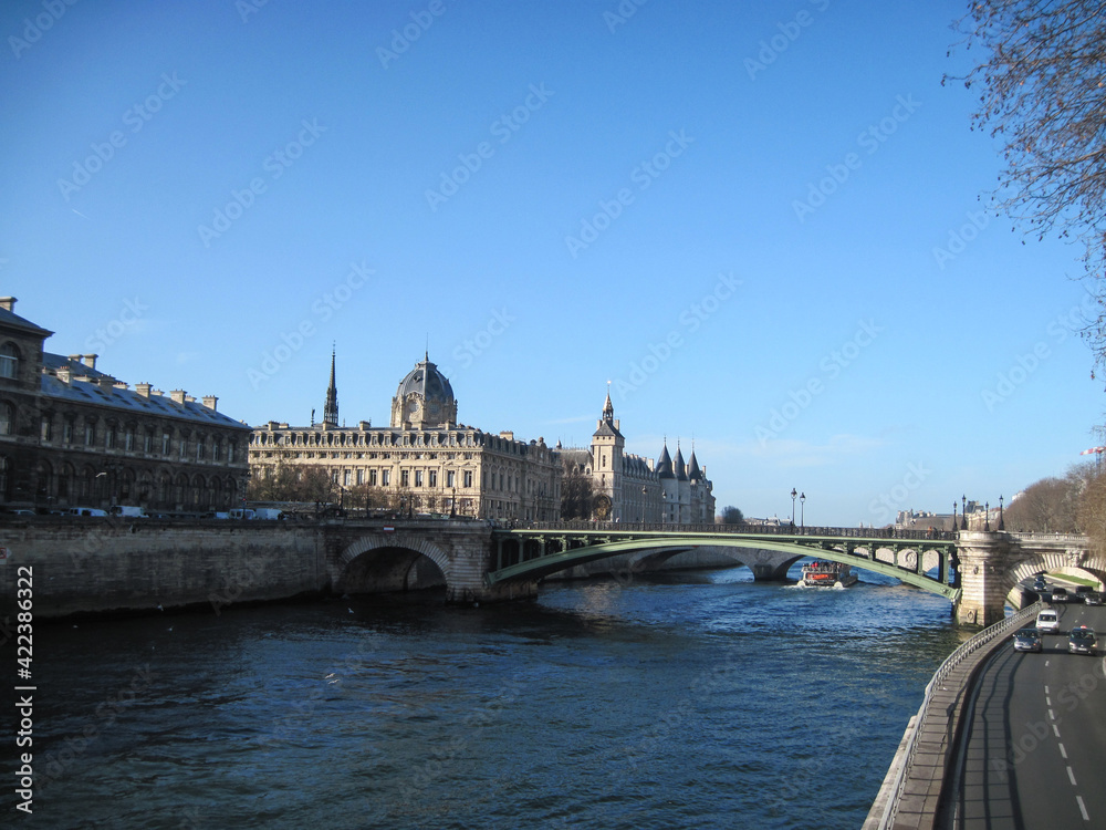 Beautiful city landscape with bridge over the Seine River on a cold spring day. Scenic view of Conciergerie palace.