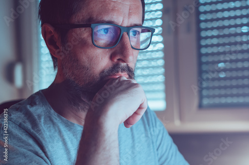 Valokuva Man wearing blue light blocking prescription glasses while looking at computer s